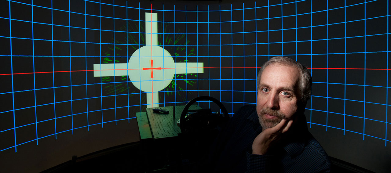 David C. Knill poses with a virtual reality system for studying sensory motor behavior in 2012. // photo by J. Adam Fenster / University of Rochester