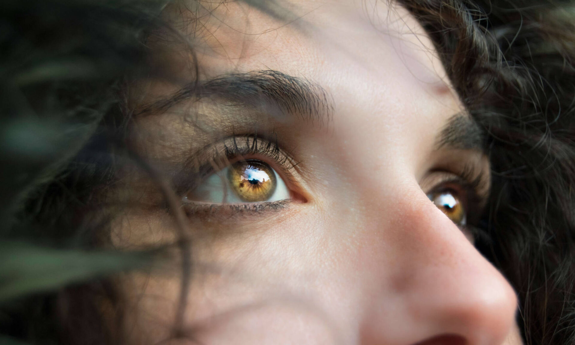 Close up of a woman's eyes and mid-face looking off camera to illustrate why eye blinking is important in humans.